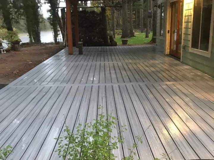 Gray composite deck leading to a covered entry at dusk