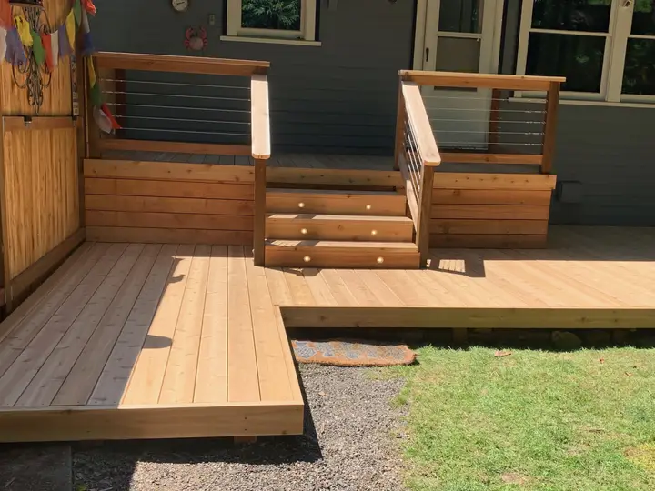 Cedar entry deck with stainless-steel cable railings and wide central steps