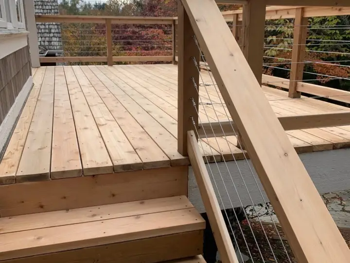 Cedar stairs with cable railing leading up to a deck